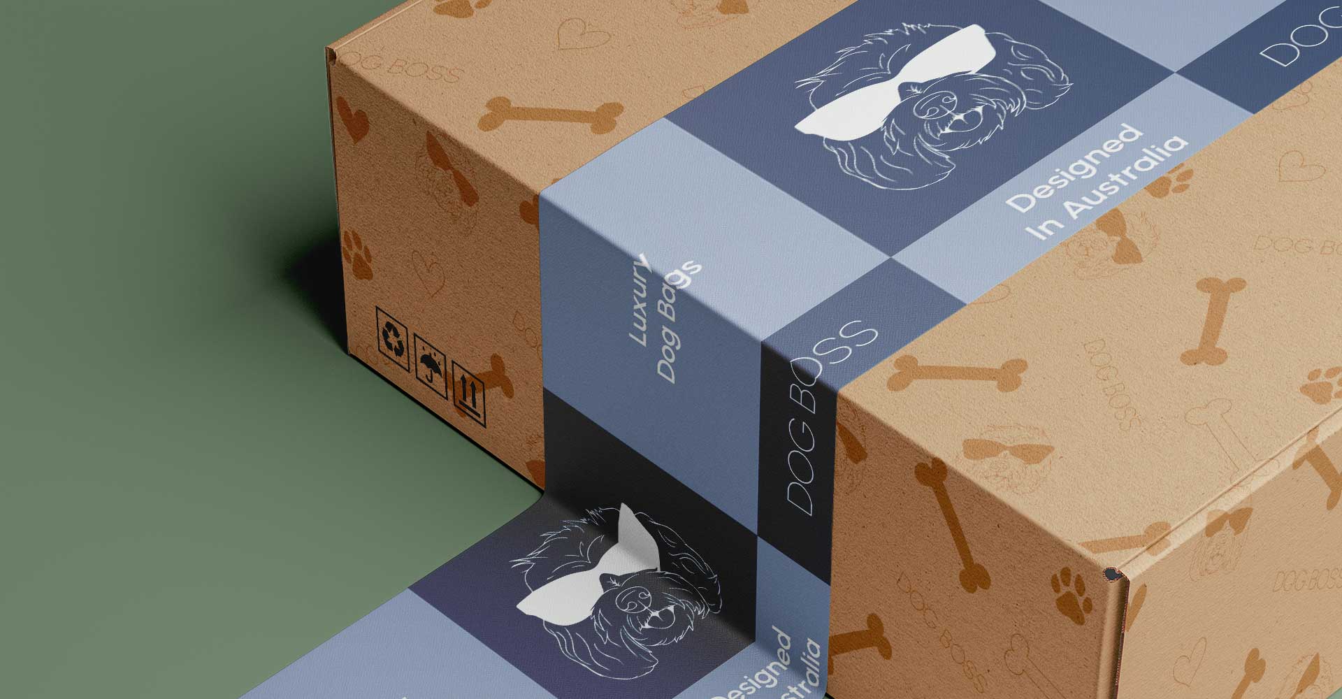 A cardboard box with dog bone and paw prints is sealed with blue tape featuring a line drawing of a dog wearing sunglasses and text that reads “DOG BOSS” and “Designed in Australia. Luxury Dog Beds.”.